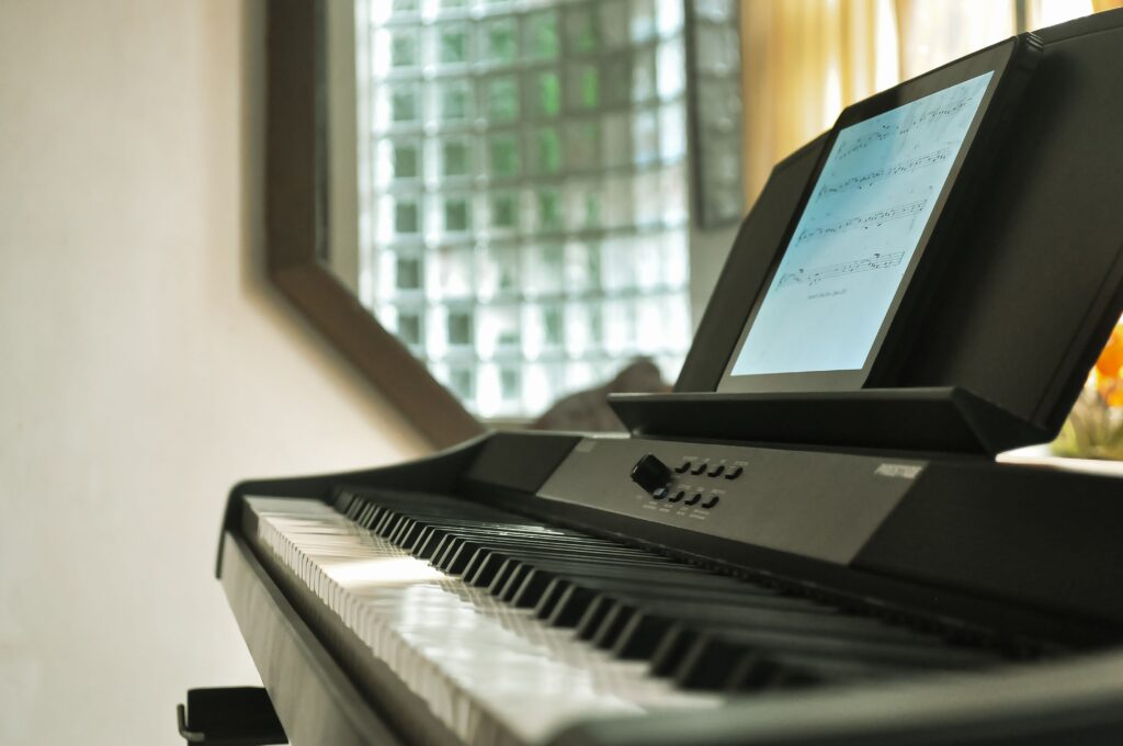 Close-up of a digital piano with a music sheet display in a well-lit room.